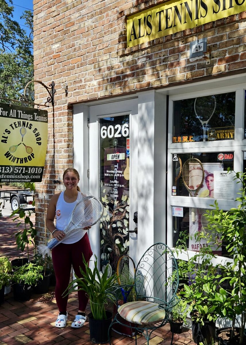 A customer outside Al's Tennis Shop with a freshly strung racquet.