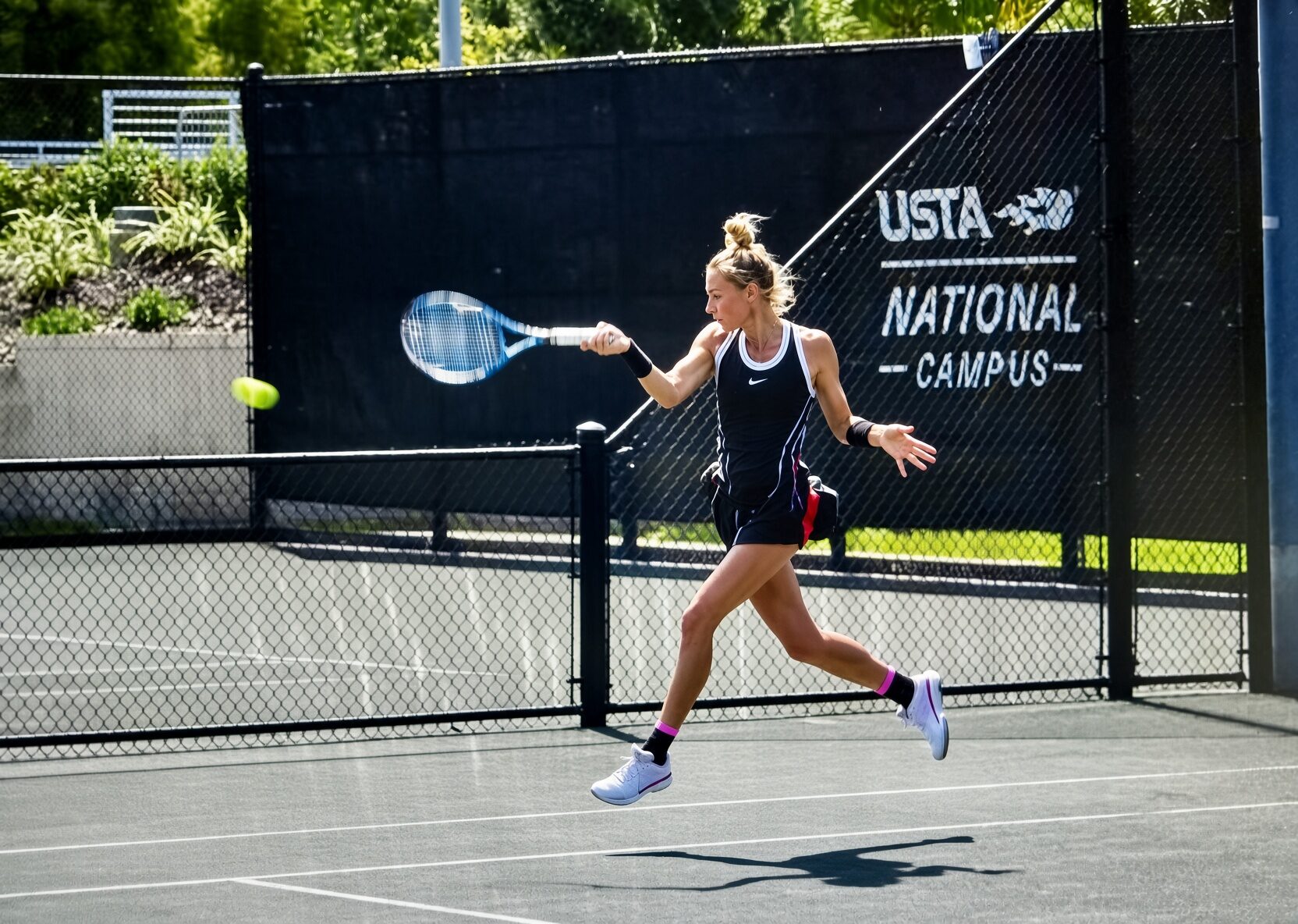 A player hits a forehand on the court at the USTA National Campus.
